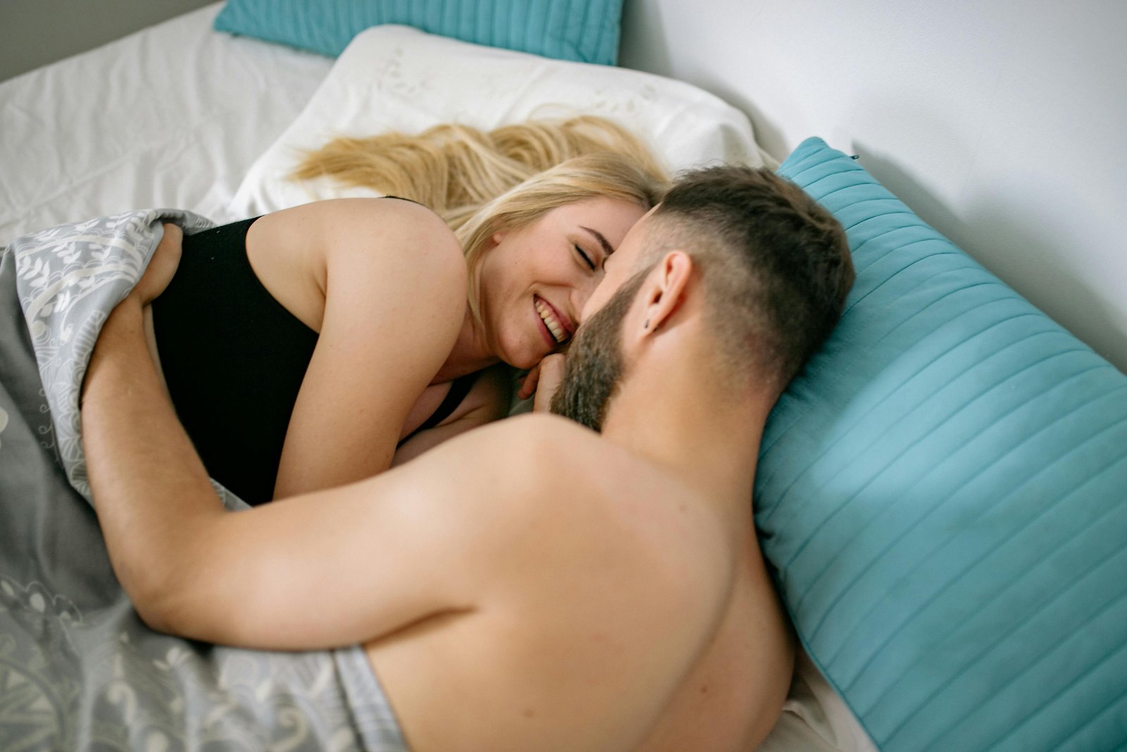 رجل وامرأة يحتضنان بعضهما البعض في السرير كبرنامج صحي